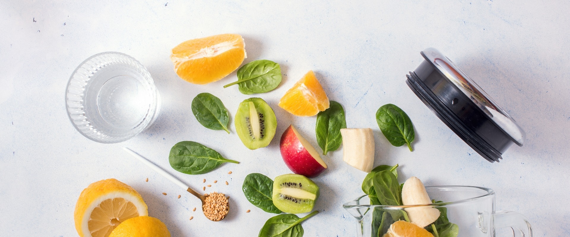 Smoothie ingredients in mixer, smoothie preparation with spinach, apple, orange, kiwi, healthy eating, detox and nutritional consultation concept